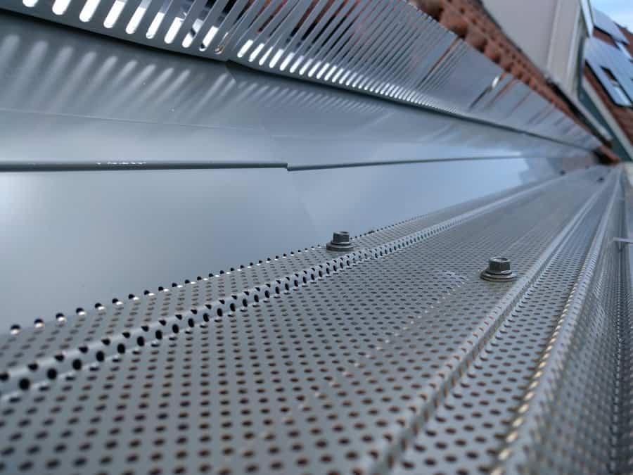 Detail van een metalen geperforeerd dakgootrooster