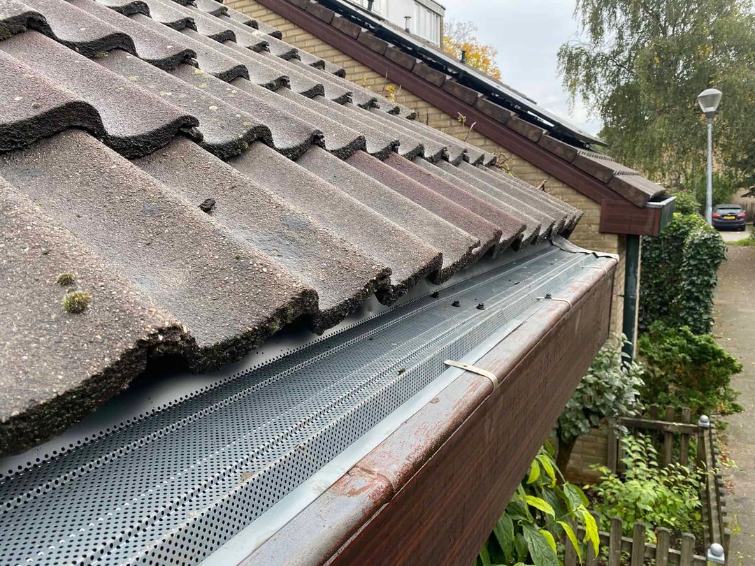 Geperforeerde dakgootroosters op maat gemonteerd in een dakgoot